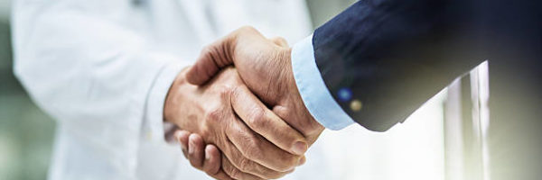 Cropped shot of a doctor shaking hands with a businessman